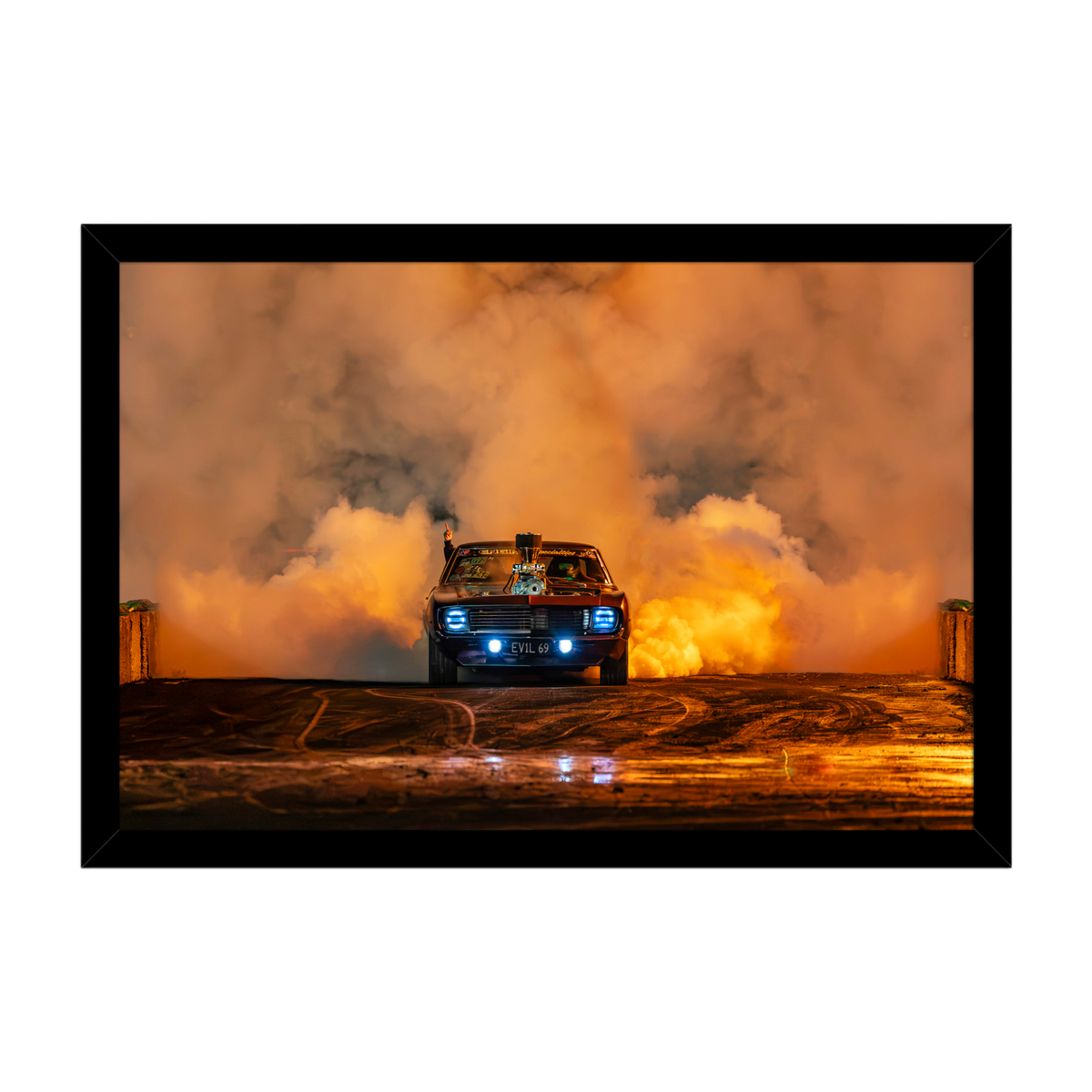 1969 Chevrolet Camaro performing a burnout surrounded by orange tyre smoke at night